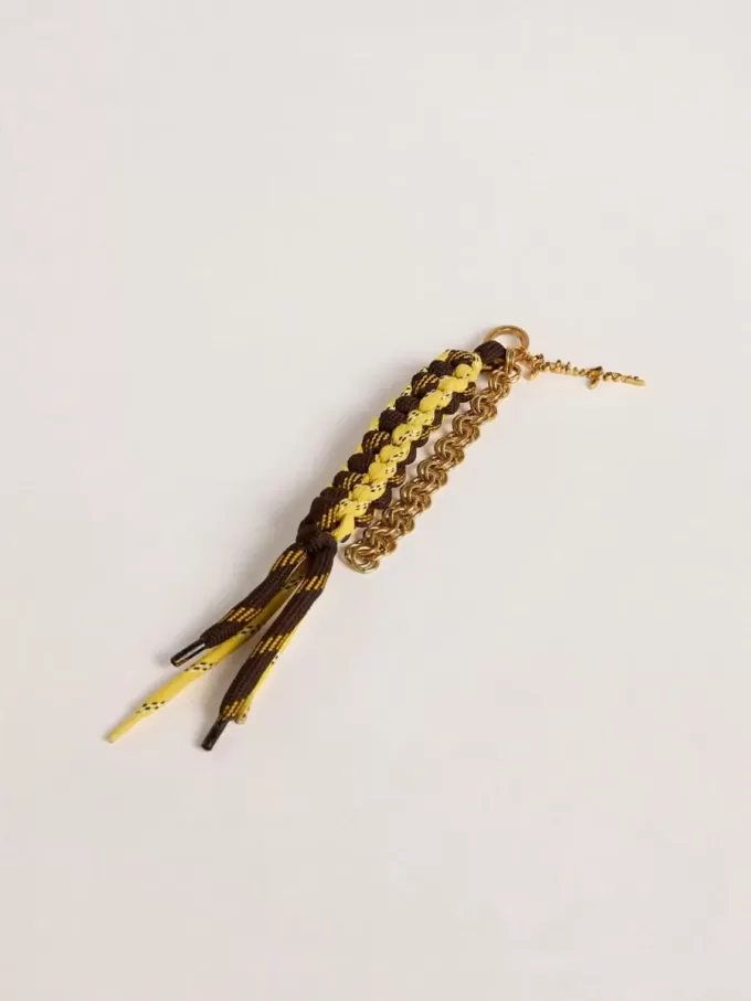 Berlock med gula och bruna knutna vandringsskosnören med kedja
