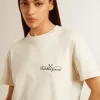 Dam-T-shirt i åldrat vitt med logotyp på bröstet