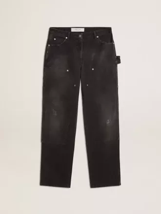Damjeans i svart bomull med slitna detaljer och patchar fram