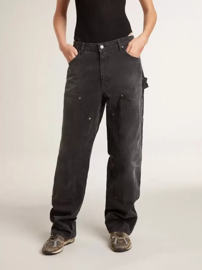 Damjeans i svart bomull med slitna detaljer och patchar fram Damjeans i svart bomull med slitna detaljer och patchar fram