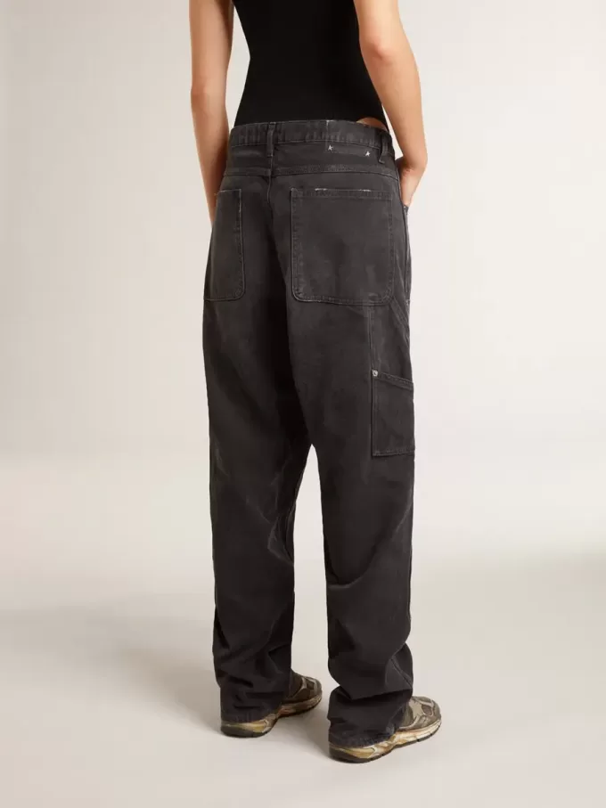Damjeans i svart bomull med slitna detaljer och patchar fram Damjeans i svart bomull med slitna detaljer och patchar fram