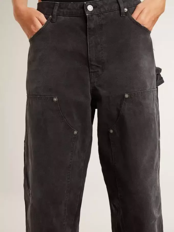 Damjeans i svart bomull med slitna detaljer och patchar fram Damjeans i svart bomull med slitna detaljer och patchar fram