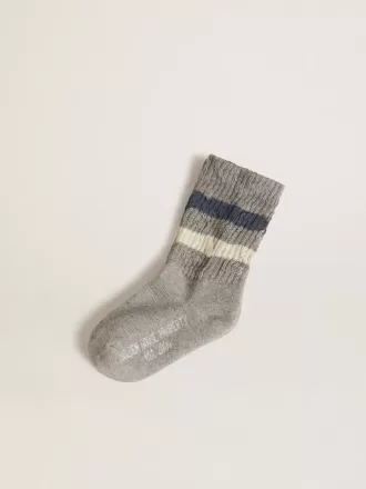 Grå barnstrumpor med slitna detaljer och slitna vita och blå ränder