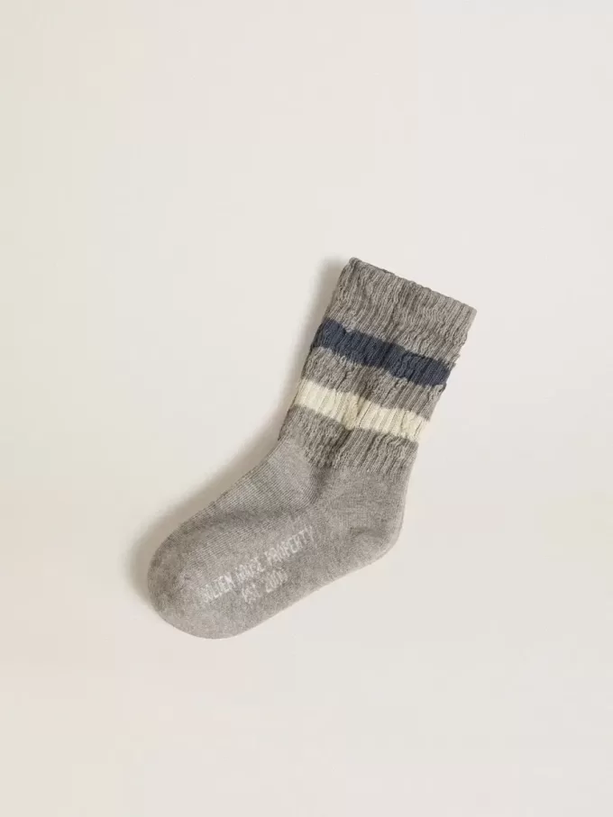 Grå barnstrumpor med slitna detaljer och slitna vita och blå ränder Grå barnstrumpor med slitna detaljer och slitna vita och blå ränder