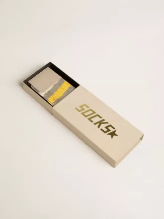 Grå strumpor med slitna detaljer och gula och vita ränder