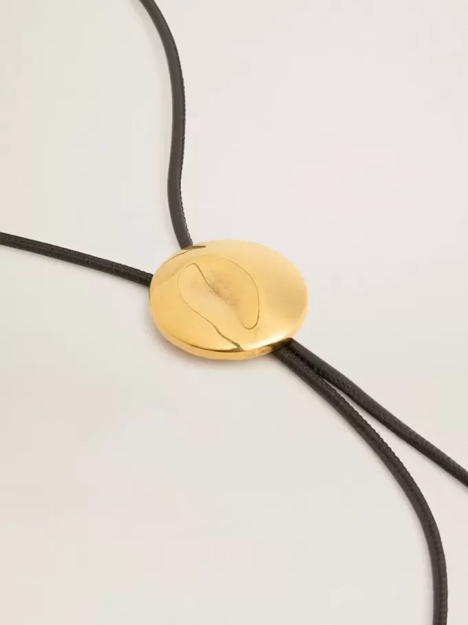 Jewelmates bolo-slips i svart läder med antikgulddetaljer i metall Jewelmates bolo-slips i svart läder med antikgulddetaljer i metall