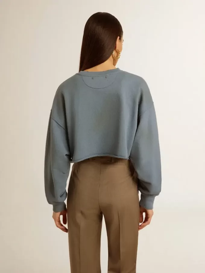 Kort sweatshirt i babyblått med slitna detaljer