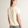 Krämefärgad dam-T-shirt med blekta röda accenter Krämefärgad dam-T-shirt med blekta röda accenter