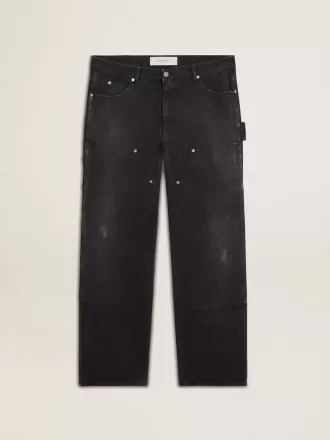 Mansjeans i svart bomull med slitna detaljer och lappar fram