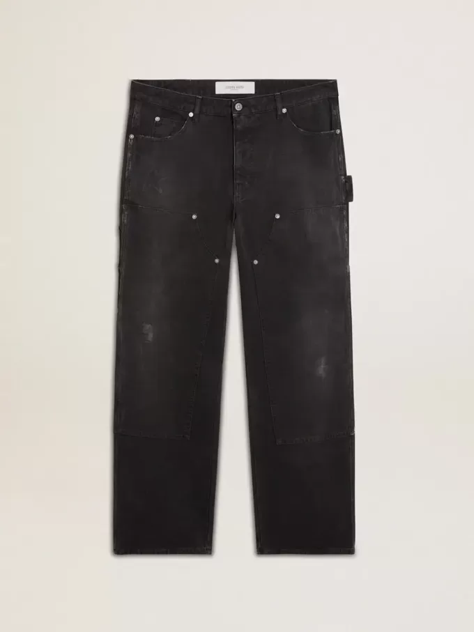 Mansjeans i svart bomull med slitna detaljer och lappar fram