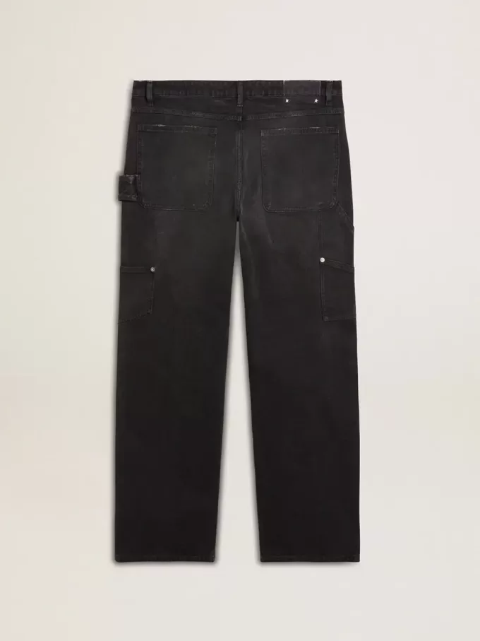 Mansjeans i svart bomull med slitna detaljer och lappar fram
