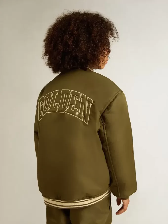 Militärgrön nylonbomberjacka för barn med text på ryggen Militärgrön nylonbomberjacka för barn med text på ryggen