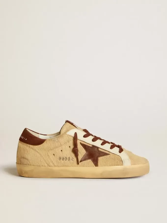Super-Star för dam i beige ponnyhud med brun mockastjärna och hälflik Super-Star för dam i beige ponnyhud med brun mockastjärna och hälflik