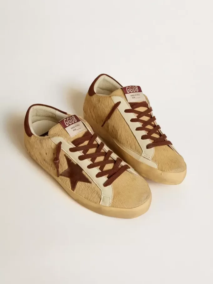 Super-Star för dam i beige ponnyhud med brun mockastjärna och hälflik Super-Star för dam i beige ponnyhud med brun mockastjärna och hälflik