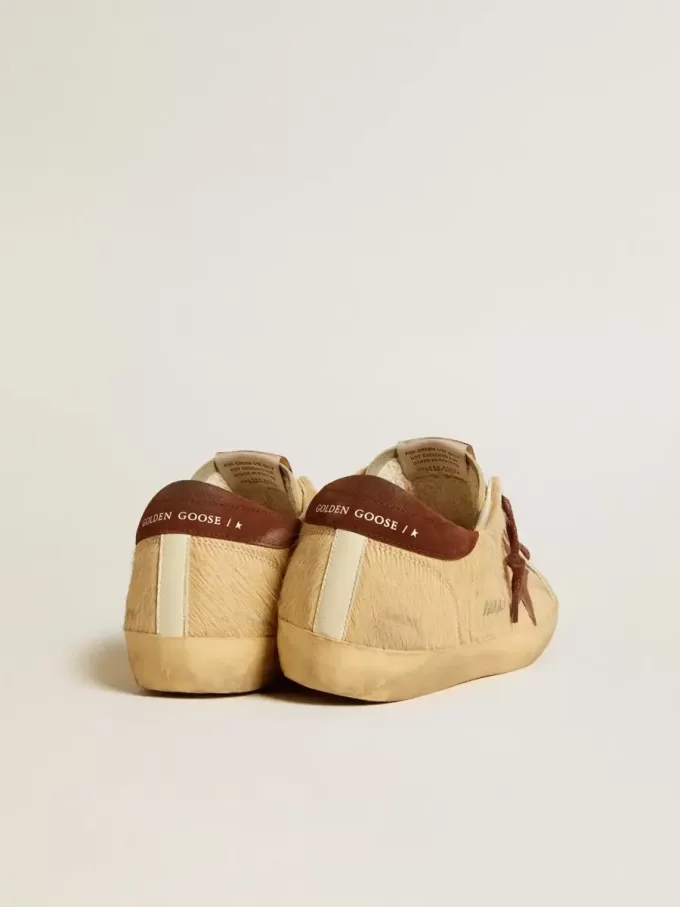 Super-Star för dam i beige ponnyhud med brun mockastjärna och hälflik Super-Star för dam i beige ponnyhud med brun mockastjärna och hälflik