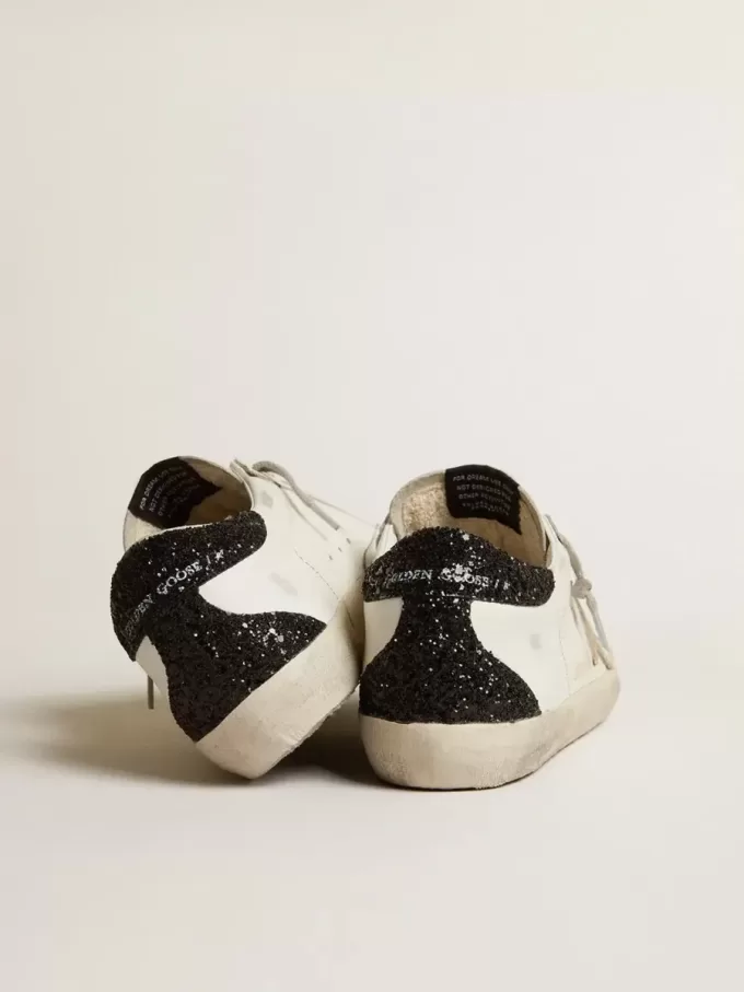 Super-Star för damer med guldstjärna och svart glitter på hälfliken Super-Star för damer med guldstjärna och svart glitter på hälfliken