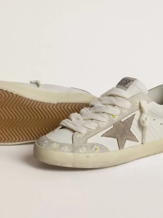 Super-Star LTD för damer med beige mockastjärna och hälflik samt blommig brodyr Super-Star LTD för damer med beige mockastjärna och hälflik samt blommig brodyr