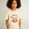 T-shirt för pojkar i slitet vitt med flerfärgade bokstäver T-shirt för pojkar i slitet vitt med flerfärgade bokstäver