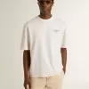 Vit unisex-T-shirt med medelhavstryck och Pescheria Golden-märke på ärmen Vit unisex-T-shirt med medelhavstryck och Pescheria Golden-märke på ärmen