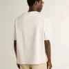 Vit unisex-T-shirt med medelhavstryck och Pescheria Golden-märke på ärmen Vit unisex-T-shirt med medelhavstryck och Pescheria Golden-märke på ärmen