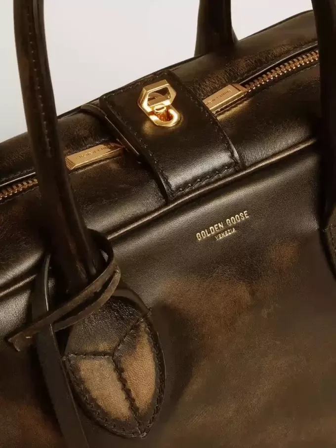 Vita Bag i svart slitet läder med gulddetaljer