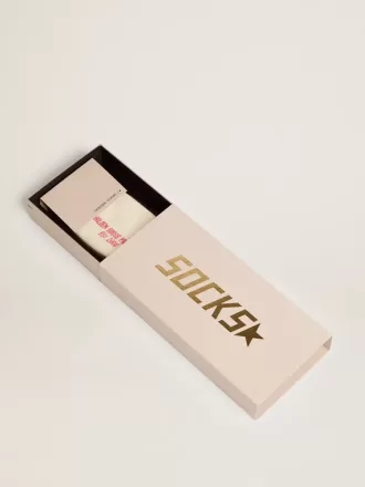 Vita strumpor med slitna detaljer och gröna och orange ränder