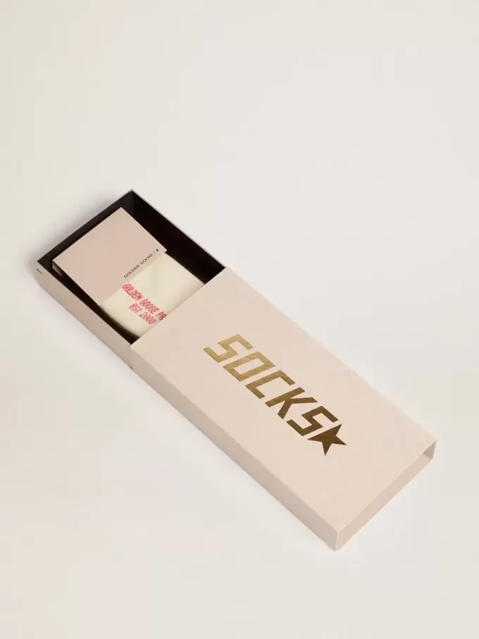 Vita strumpor med slitna detaljer och gröna och orange ränder